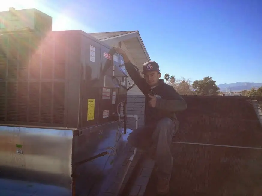 HVAC technician performing HVAC Inspection on a rooftop unit in Mentor